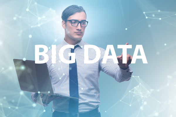 The image shows a data scientists using a computer to conduct data science. Big data is displayed over the top of the image.